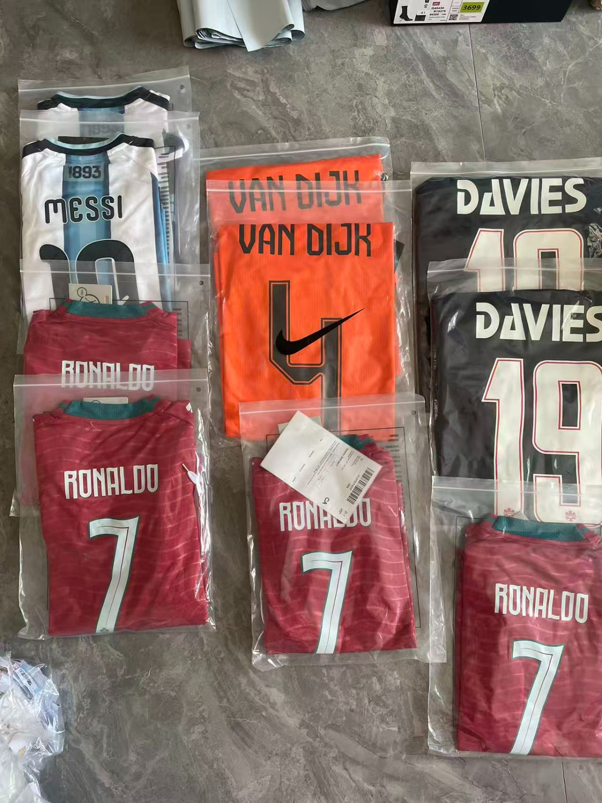 Collection of national team jerseys including Messi, Van Dijk, Davies, and Ronaldo